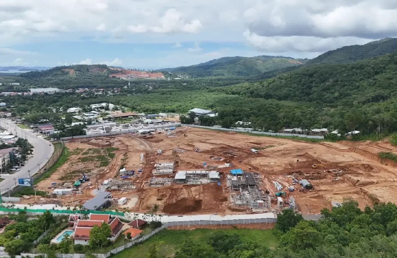 Drone survey, July 2026: villa structures with steel rebar on the cleared site, the sea in the distance